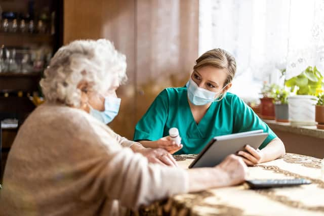 A staff member speaks with a resident at a care home