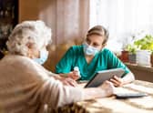 A staff member speaks with a resident at a care home