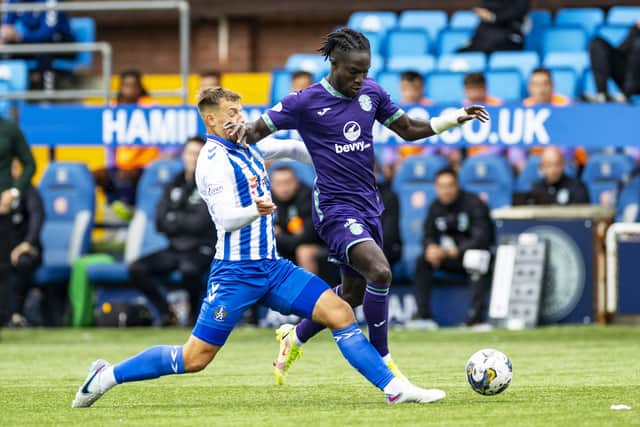 Kilmarnock's Brad Lyons and Hibernian's Elie Youan tussle for possession.