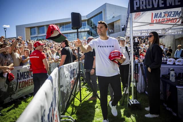 The conservative commentator Charlie Kirk hands out hats before speaking at Utah Valley University in Orem, Utah, where he was shot on Wednesday, September 10, 2025. (Tess Crowley/The Deseret News via AP)