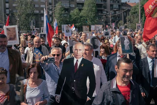 A man holds a cutout of Russian President Vladimir Putin during the "Immortal Regiment" pro-Russia march in Belgrade, Serbia, last year.