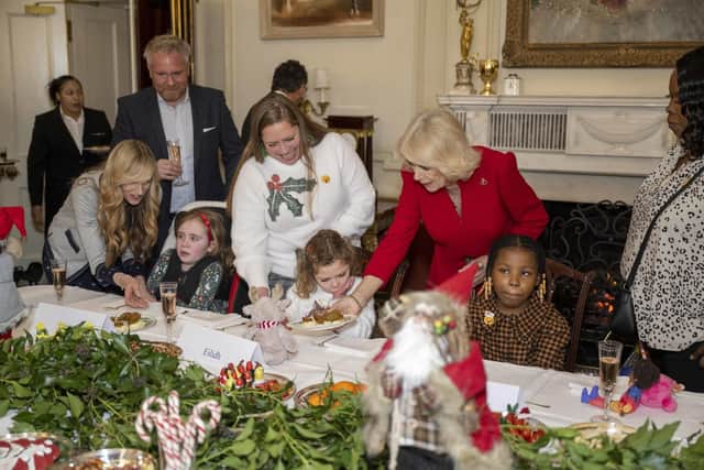 The Queen Consort, serving food to Eilidh Currie (centre) during an event at Clarence House in London. Eilidh, five, and her three-year-old brother Cameron saw reindeer, helped decorate the tree and met Father Christmas on their visit to Clarence House. Picture: Paul Grover/Daily Telegraph/PA Wire
