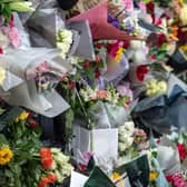 A young boy lays flowers outside Buckingham Palace