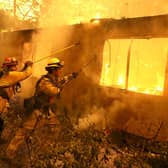 Firefighters try to keep flames from burning home from spreading to a neighboring apartment complex as they battle the Camp Fire in 2018 in Paradise, California (Picture: Justin Sullivan/Getty Images)