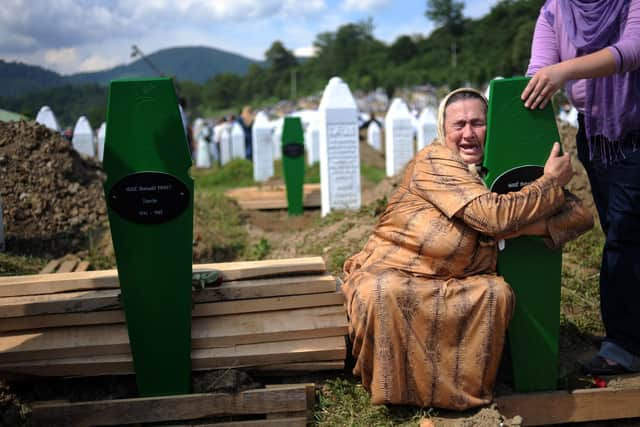 A Bosnian woman cries over the newly dug graves of her two sons at a cemetery near Srebrenica in 2010, 15 years after nearly 8,000 Muslims were murdered (Picture: Dimitar Dilkoff/AFP via Getty Images)