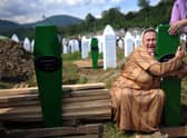 A Bosnian woman cries over the newly dug graves of her two sons at a cemetery near Srebrenica in 2010, 15 years after nearly 8,000 Muslims were murdered (Picture: Dimitar Dilkoff/AFP via Getty Images)