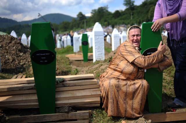 A Bosnian woman cries over the newly dug graves of her two sons at a cemetery near Srebrenica in 2010, 15 years after nearly 8,000 Muslims were murdered (Picture: Dimitar Dilkoff/AFP via Getty Images)