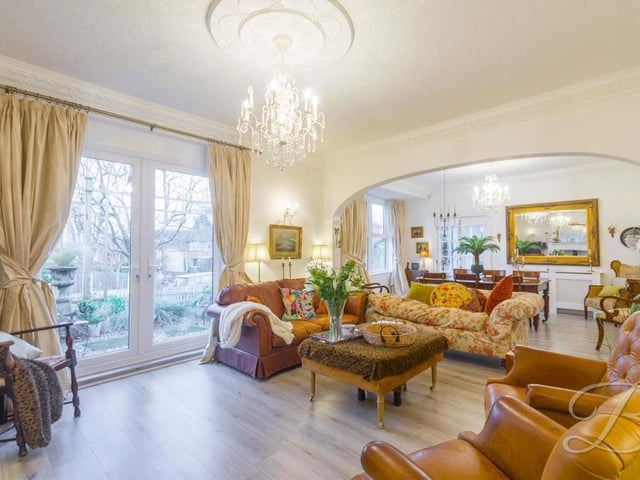 The main living room from a different angle, which shows how light it is, thanks largely to giant double doors that lead out to the front of the property. The floor is laminated, and in the background, you can see the dining room.