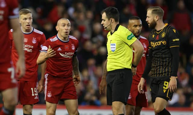 Aberdeen's Scott Brown (left) speaks to referee Don Robertson during the defeat by Motherwell.