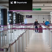 Passengers, wearing a protective face masks, wait at the check-in area at Edinburgh Airport