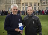 Clive Brown, the new Captain of The Royal and Ancient Golf of St Andrews, presents a Gold Sovereign to caddie Martin O’Brien.