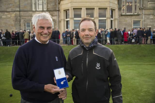 Clive Brown, the new Captain of The Royal and Ancient Golf of St Andrews, presents a Gold Sovereign to caddy Martin O'Brien.