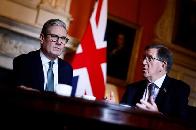 Former defence secretary Lord Robertson, pictured right with Sir Keir Starmer, says Britain needs to 'move away from a peacetime mode' and households should prepare for attacks by stocking up on candles and battery-operated torches and radios (Picture: Benjamin Cremel - WPA Pool/Getty Images)