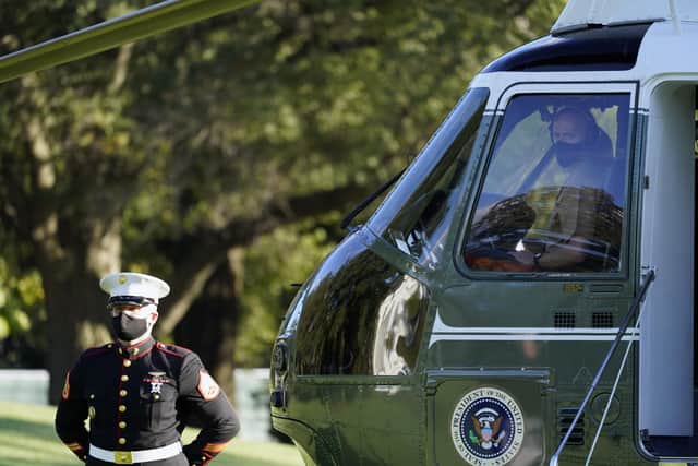 The pilot of Marine One wears a face mask as President Donald Trump prepares to leave the White House to go to Walter Reed National Military Medical Center
