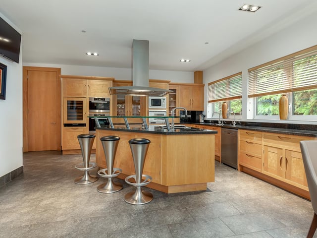Interior: Its striking entrance hall is dominated by an extraordinary swooping grand staircase, and leads to a sitting room, kitchen, family room with bar, gym, conservatory and swimming pool. The first floor has an office and four ensuite bedrooms. The principal bedroom, with ensuite and jacuzzi, is on the top storey.