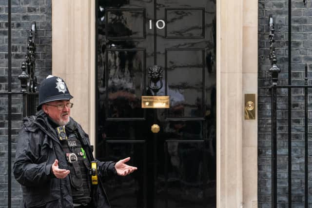 A police officer gestures to colleagues outside 10 Downing Street