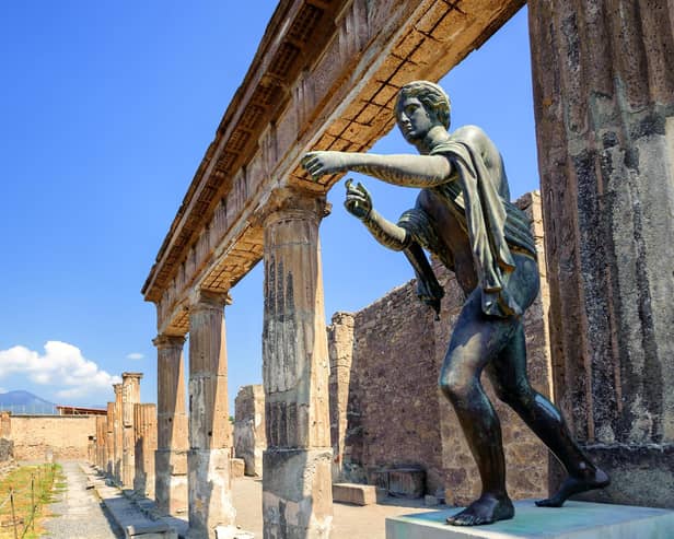 Ruins of the antique Temple of Apollo with bronze Apollo statue in Pompeii, Naples, Italy. Pompeii was destroyed by Vesuvius eruption in 79 AD.