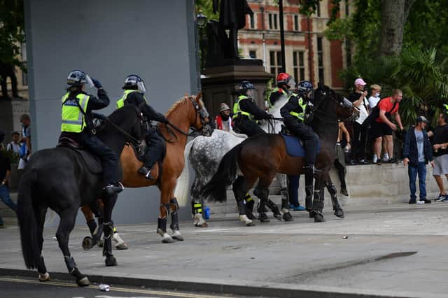 Bottles are thrown at mounted police as members of far-right groups gathered to guard statues in Parliament Square. Picture: Getty