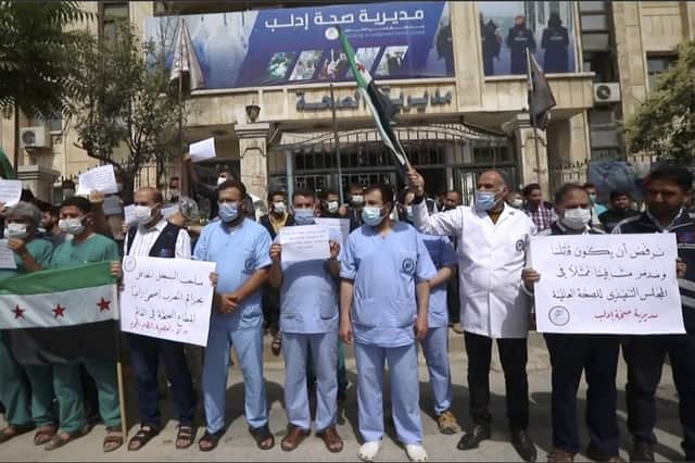 Dozens of medical workers protest against a decision to grant Syrian President Bashar Assad's government a seat on the executive board of the World Health Organisation in Idlib, Syria (Picture: AP)