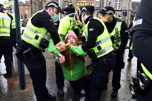 Police officers arrest a member of the public at an anti lockdown protest held by The Scotland Against Lockdown group outside the Scottish Parliament. Picture: Andy Buchanan/AFP via Getty Images