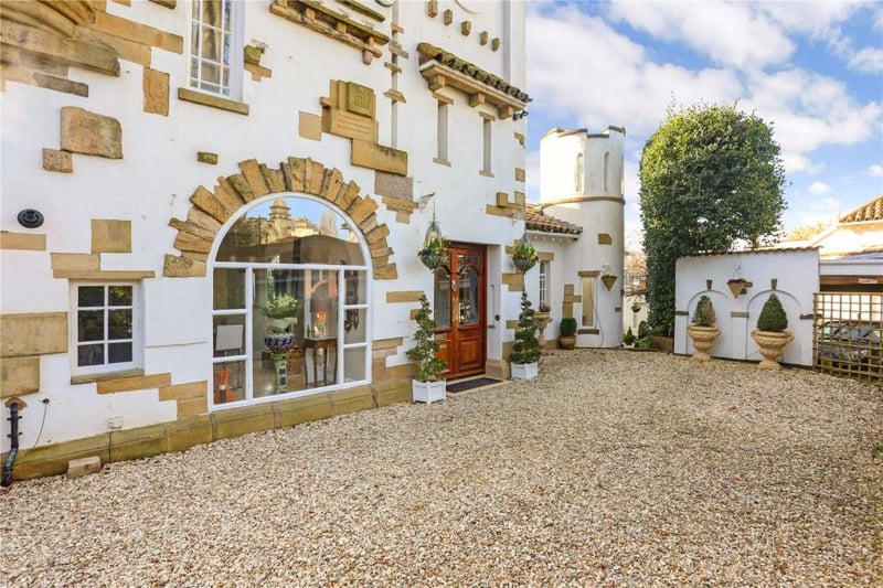 A gravelled driveway leads to the front door and provides parking for three cars.