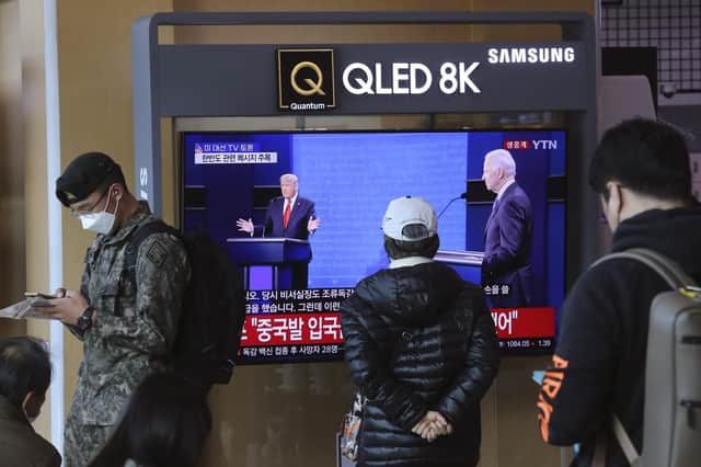 A battle for America's soul: The election debate between Donald Trump and Joe Biden is watched by passersby in Seoul Railway Station, South Korea (Picture: Ahn Young-joon/AP)