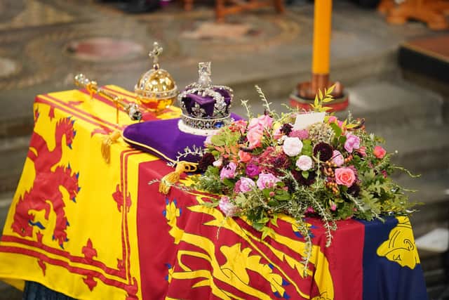 The coffin of Queen Elizabeth II, draped in the Royal Standard with the Imperial State Crown and the Sovereign's Orb and Sceptre, during her State Funeral at the Abbey in London.