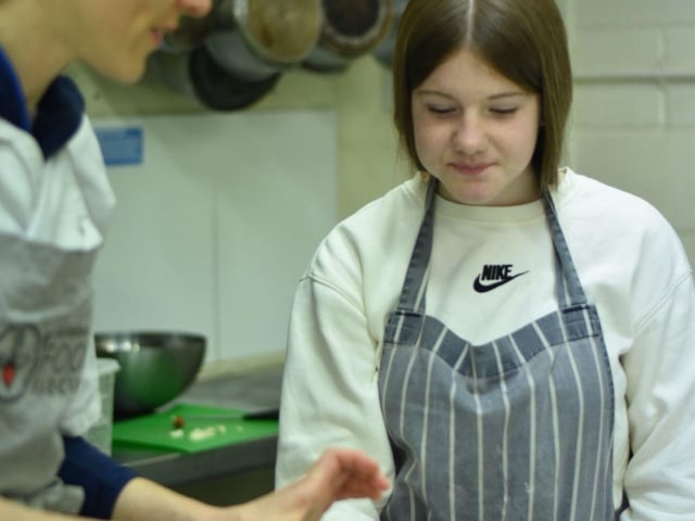 A participant and one of Edinburgh Food Social's chef-activists portioning a tart.