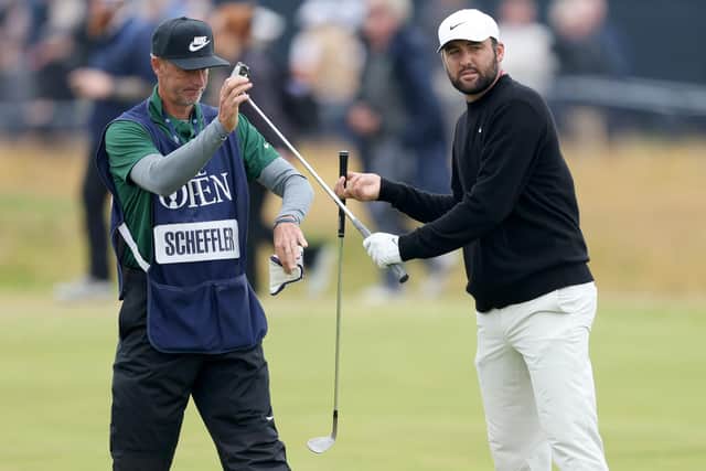 Scottie Scheffler is handed a club by caddie Ted Scott on the 18th hole during day two of the 152nd Open. Picture: Picture: Warren Little/Getty Images.