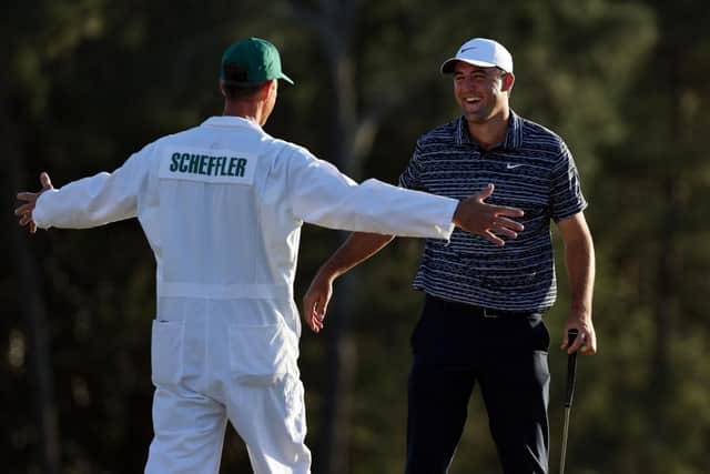 Scottie Scheffler and caddie Ted Scott celebrate on the 18th green after winning the Masters at Augusta National Golf Club. Picture: Gregory Shamus/Getty Images.