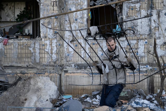 A worker clears debris outside an apartment block burnt by pieces of a fallen Russian missile in Kyiv's Obolon district.

Photojournalist Bennett Murray captured scenes on March 14 in Obolon district, Kyiv, Ukraine.