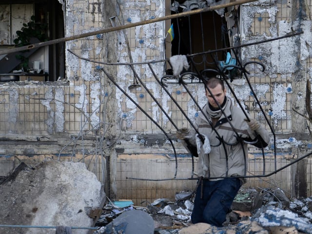 A worker clears debris outside an apartment block burnt by pieces of a fallen Russian missile in Kyiv's Obolon district.
Photojournalist Bennett Murray captured scenes on March 14 in Obolon district, Kyiv, Ukraine.