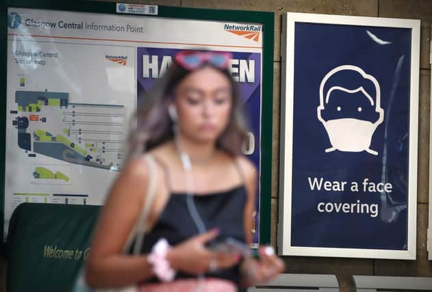 A passenger walks past a sign at the entrance to Glasgow Central Station as Scotland continues to lift coronavirus lockdown measures.