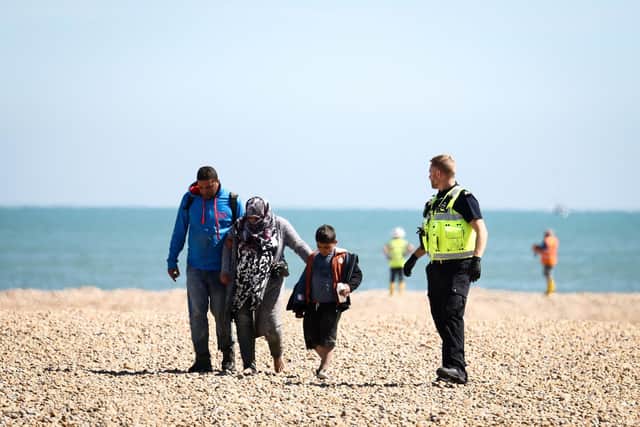 Migrants leave an RNLI lifeboat that picked them up at sea while crossing the English Channel from France (Picture: Henry Nicholls/AFP)