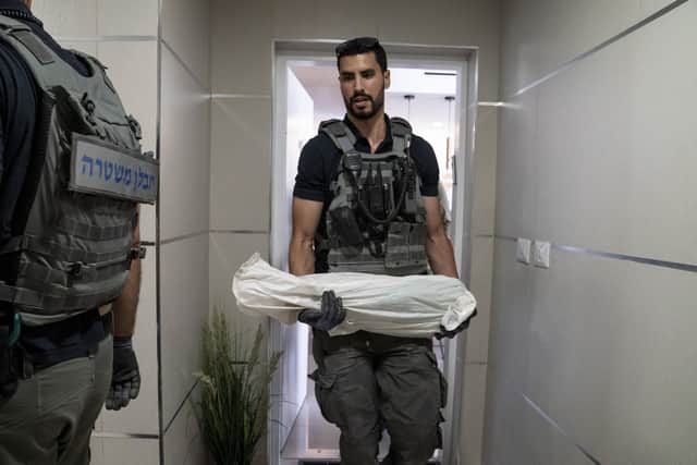 An Israeli technician removes an unexploded missile fired from the Gaza Strip that landed on the top floor of a high-rise apartment building in Ashkelon, southern Israel (Picture: John Minchillo/AP)