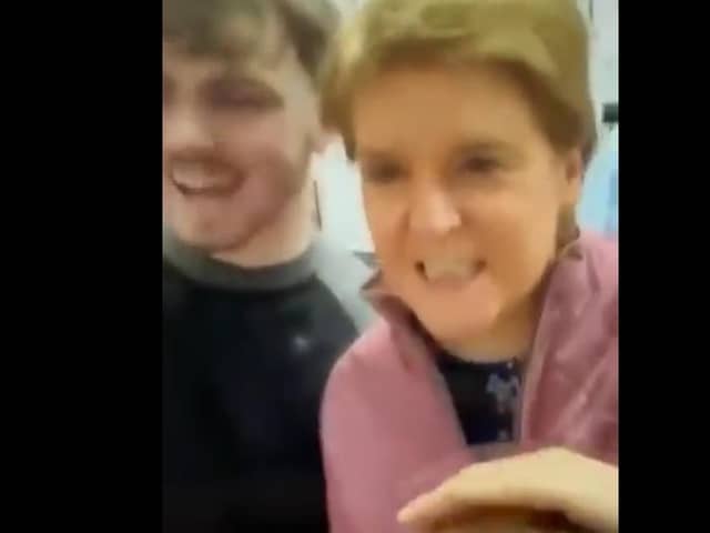 The video shows Nicola Sturgeon not wearing a face mask in a public setting.