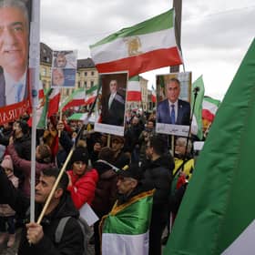Demonstrators carry historic flags of Iran and portraits of Reza Pahlavi, the oldest son of the last Shah of Iran, during a rally outside the Munich Security Conference (Picture:Odd Andersen/AFP via Getty Images)
