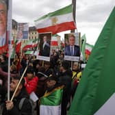 Demonstrators carry historic flags of Iran and portraits of Reza Pahlavi, the oldest son of the last Shah of Iran, during a rally outside the Munich Security Conference (Picture:Odd Andersen/AFP via Getty Images)