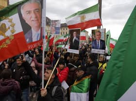 Demonstrators carry historic flags of Iran and portraits of Reza Pahlavi, the oldest son of the last Shah of Iran, during a rally outside the Munich Security Conference (Picture:Odd Andersen/AFP via Getty Images)