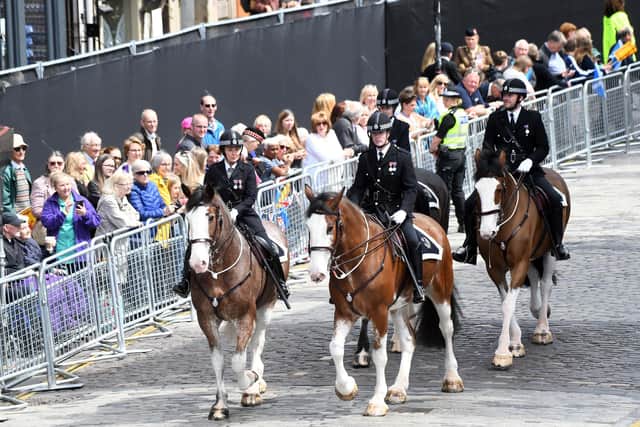 Police officers on horseback patrol along the Royal Mile ahead of the National Service of Thanksgiving and Dedication to the coronation of King Charles III and Queen Camilla