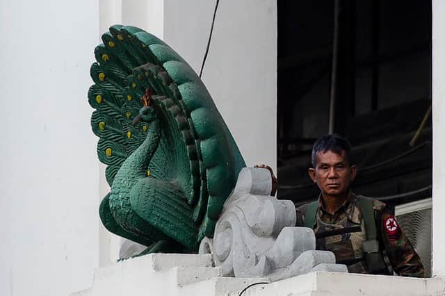 A soldier stands guard in City Hall in Yangon on Monday, after Myanmar's military seized power in a bloodless coup, detaining democratically elected leader Aung San Suu Kyi and imposing a one-year state of emergency. (Picture: STR/AFP via Getty Images)