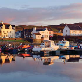 A view of the rocky shore of a small town Port Ellen at sunrise