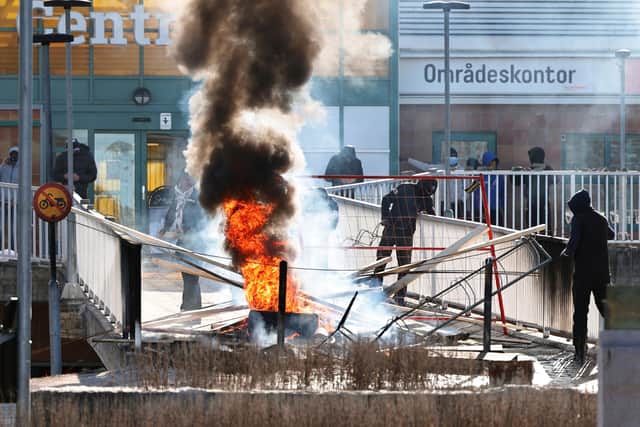 Protesters burn a barricade at the entrance to a shopping center during rioting. Photo: Stefan JERREVANG / various sources / AFP via Getty Images.