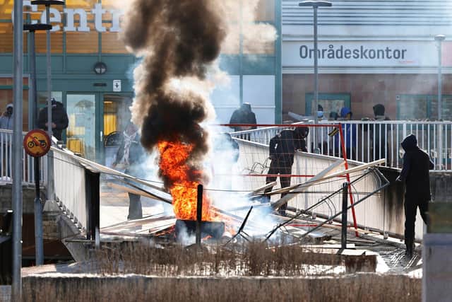 Protesters burn a barricade at the entrance to a shopping center during rioting. Photo: Stefan JERREVANG / various sources / AFP via Getty Images.