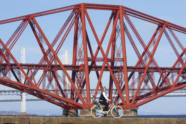 Woman enjoys the sun as she cycles in South Queensferry near the Forth Bridges (Photo: SWNS)