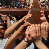 Christians in Jerusalem carry their large wooden cross along the route tradition says Jesus carried the cross on, to mark Good Friday