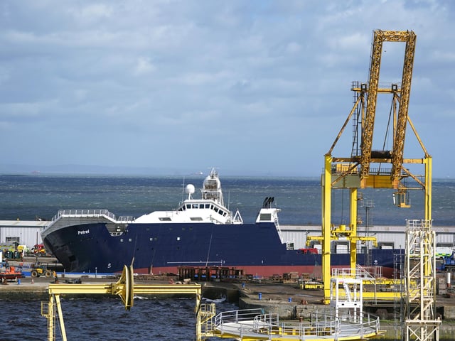 Emergency services at Imperial Dock in Leith, Edinburgh, where a ship has become dislodged from its holding and is partially toppled over. Picture date: Wednesday March 22, 2023.