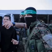 An image from a handout video released by the Hamas Media Office showing members of its Al-Qassam Brigades leading hostages over to officials from the International Committee of the Red Cross in Gaza on Friday. Picture: Hamas Media Office/AFP via Getty Images