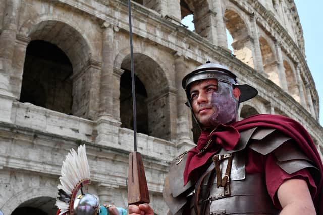 A man in a Roman Centurion costume takes part in a parade in front of the Colosseum in Rome. A reader suggests climate change was a major factor in the fall of the Roman Empire