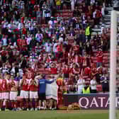 The Denmark players form a shield around their stricken team-mate Christian Eriksen as he receives treatment from medics.
